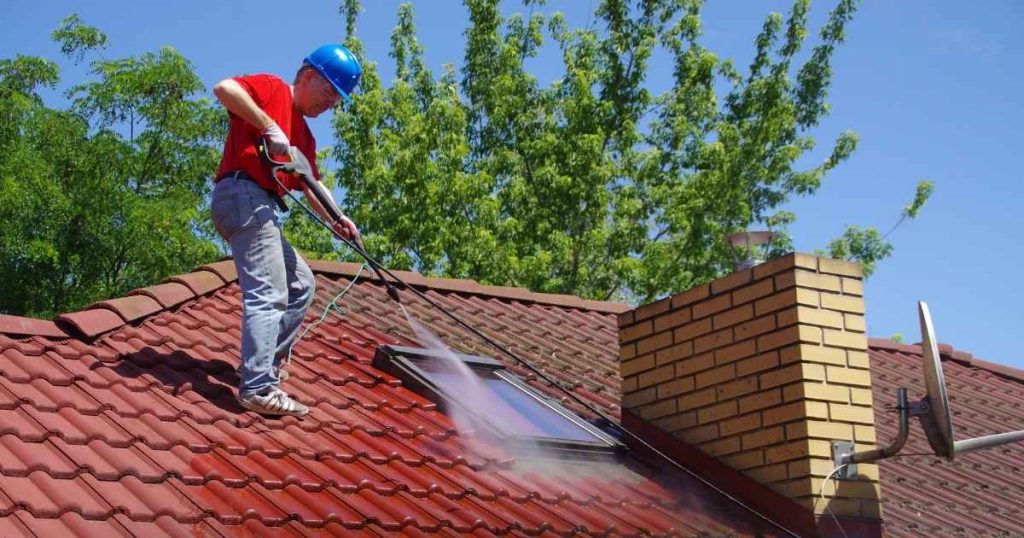 A man power washing house roof