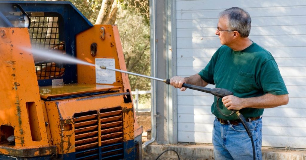 A man washes his car with a rental pressure washer
